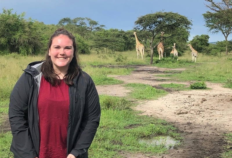 Jennifer Kristin Clark on Safari with Giraffe in background